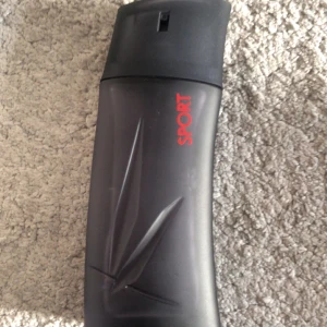 Kenzo Homme Sport Eau de Toilette - Kenzo Homme Sport är en herrparfym med en sportig och fräsch doft. Flaskan är matt mörkgrå med röd text och har en stilren, modern design med Kenzo-loggan ingraverad. Perfekt för dig som gillar energiska och fräscha toner. Ungefär 40 ml av 50 ml 