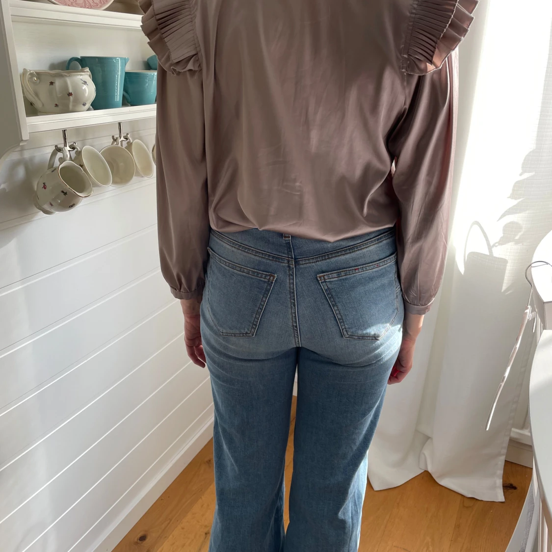 Beige blus med puffärmar och plisserade axlar, guldfärgade knappar och trekvartsärmar. - 1