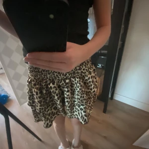  volangkjol - Säljer en kort kjol med leopardmönster och bred resår i midjan. Lappen är avklippt men är i storlek S.