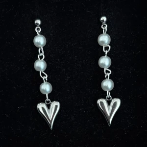Silverfärgade örhängen med pärlor och hjärtan - Handgjorda och unika silverörhängen  🤩 Hela örhänget är i 100% rostfritt stål (ej silverpläterat) 💕🙏5 cm långa. Alla köp görs via ”KÖP NU” knappen.  💐