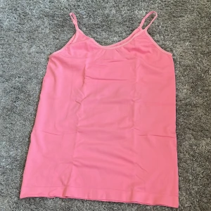 Rosa linnetopp med smala axelband - Säljer en enkel och snygg rosa linnetopp med smala axelband. Perfekt till sommaren och lätt att matcha med jeans eller kjol. Tunn och skön modell som passar till många tillfällen.