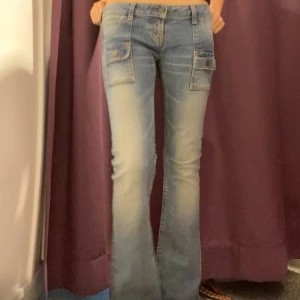 Bootcut low waist jeans från Black by Moussy - Snygga långmidjade och bootcut blå jeans från Black by Moussy med unika fickdetaljer och knappar. De har en klassisk femficksdesign och en bekväm passform. Perfekta för en avslappnad stil.