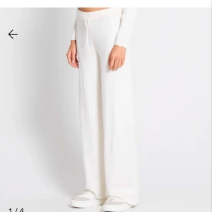 Vita mjukisbyxor med dragsko - Säljer ett par vita mjukisbyxor med bred resår i midjan och dragsko. Byxorna har en rak och loose passform, perfekta för en avslappnad stil. Tillverkade i mjukt bomullsmaterial för extra komfort. Har aldrig använt dom, helt nya prislappen är borta men helt nya