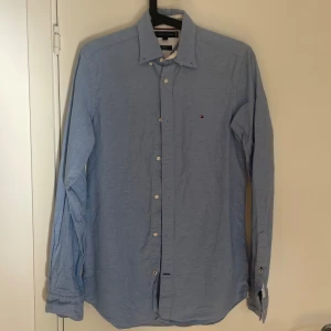 Ljusblå skjorta från Tommy Hilfiger - Klassisk ljusblå skjorta från Tommy Hilfiger. Skjortan har långa ärmar, knappar framtill och en klassisk krage. Perfekt till alla typer av outfits. Storlek xs. Nypris ca 799, mitt pris endast 249. DM för funderingar!