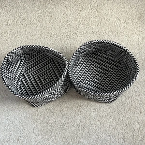 Svartvit mönstrad tygkorg - Två snygga tygkorgar i svartvitt zickzackmönster. Perfekta som accessoar för förvaring av småsaker eller som dekoration i rummet. Korgarna är mjuka och flexibla med rund form och modern look. För en är det 20kr men för båda är det 40kr.Dem har hjälpt mig i många år men nu behöver jag inte dem längre, jag hoppas att ni kommer tycka om dem!❤️❤️