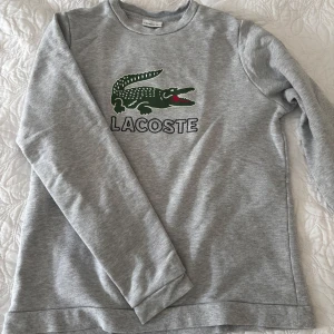 Lacoste tröja - Säljer nu denna snygga Lacoste tröja. Storlek 164cm. Passar perfekt till allt. Tveka inte på att höra av dig vid minsta lilla fundering!