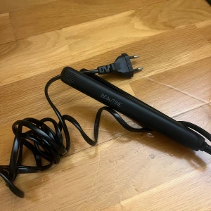 Mini platttång - En stilren svart plattång med sladd och europeisk kontakt. Använd 1 gång, perfekt att bara stoppa ner i väskan!