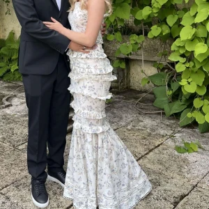 Vit blommig långklänning med volanger från Boohoo - Supersöt långklänning från Boohoo, storlek 36, helt slutsåld och endast använd en gång. Vit med blommor på. Perfekt för bal eller till sommaren!