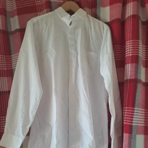 Vit skjorta från Admiral - Klassisk vit skjorta från Admiral i storlek M. Skjortan har lång ärm, knappar framtill och en bröstficka. Perfekt till skjorta-looks och enkel att matcha med olika outfits.
