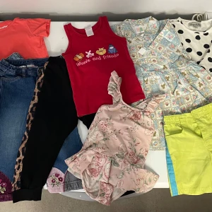 Klädpaket flicka storlek 86-92 - Nio plagg. Supersöt rosa klänning med blommigt mönster och volangdetaljer.prickig klänning . Två par jeans mm Perfekt för sommarens varma dagar.