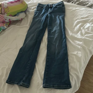 Blå bootcut jeans 90s bootcut 🤍 - Säljer ett par klassiska blå jeans med bootcut passform. Jeansen har normal midja, knapp och dragkedja framtill samt fickor både fram och bak. Perfekta till vardags för en avslappnad stil.