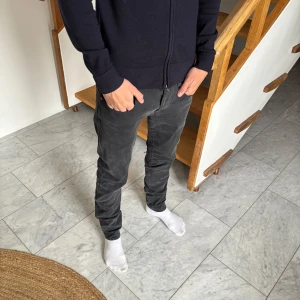 Mörkgrå Replay jeansbyxor - Säljer ett par grås replay anbass hyperflex. De är i ett mycke bra skicka bara använda fåtal gånger. Storleken är 31/32, hör gärna av er vid frågor.