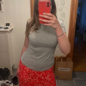 Röd blommig kjol från Holly & White - Säljer en röd blommig kjol från Holly & White i storlek XS. Kjolen har ett vitt och blått blommönster och resår i midjan. Endast använd en gång!💘