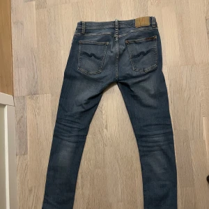 Nudie Jeans ”tight terry” - Säljer ett par klassiska blå jeans från Nudie Jeans med schyssta kontrastsömmar. Modellen är tight terry vilket passar en slim passform. Byxorna är i mycket bra skick och storlek 30/31. Bara att höra av sig vid ev frågor!