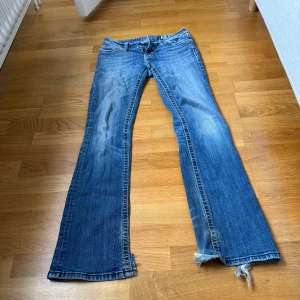 Miss Me jeans - Blå low waist bootcut miss me jeans som är lite slitna längst ned och på bakfickorna, annars inga defekter. Innerbenslängden är 82 cm och midjan rakt över är 33 cm. Skriv för fler frågor eller bilder
