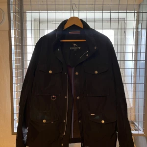 Svart jacka från Snoot - Säljer en svart jacka från Snoot med flera fickor framtill, knappar och dragkedja. Klassisk design med krage och detaljer i metall. Perfekt för dig som vill ha en stilren och funktionell jacka. Jackan ät i storlek L men passar snarare M. Små i storleken men perfekt för Medium. Skön vår jacka. 