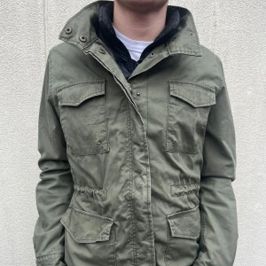 Grön fieldjacket från Dobber - Säljer en grön fieldjacka från Dobber i storlek medium. Jackan har flera fickor och en dragkedja framtill. Perfekt för våren som kommer nu med sin stilrena design och praktiska detaljer.