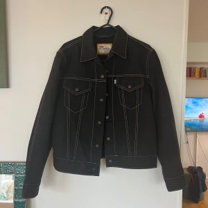 Svart jeansjacka från Levi's - Säljer en svart jeansjacka från Levi's med kontrasterande vita sömmar 