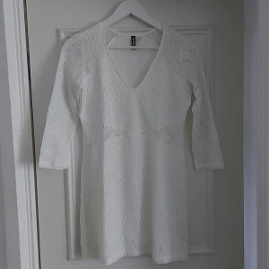 Vit spetströja med v-ringning från H&M  - Säljer en vit spetströja från H&M med v-ringning och trekvartsärm. Tröja har ett fint spetsmönster och är figurnära utan att vara tight. Perfekt för somriga tillfällen !