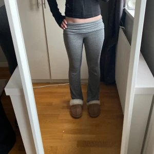 Grå mjukisbyxor från Gina Tricot - Gråa mjukisbyxor från Gina Tricot med låg midja och utsvängda ben. Byxorna är i mjukt bomullsmaterial och har en bekväm passform som sitter snyggt över höfterna. Perfekta för en avslappnad stil.