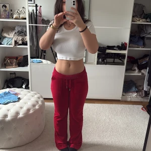 Röda mjukisbyxor från Juicy Couture - Säljer ett par klassiska röda mjukisbyxor från Juicy Couture med dragsko i midjan och fickor bak med knappdetalj. Helt nytt skick, knappt använda. Jag har matchande zip hoodien om man är intresserad i att ha ett sett, öppen för att sälja den tillsammans med byxorna. Pris kan diskuteras ❣️