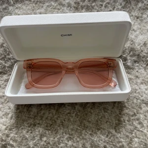Rosa solglasögon från CHIMI - Snygga solglasögon från CHIMI i en transparent rosa färg. Modellen 04 har rektangulära bågar och matchande rosa glas. Kommer i ett stilrent vitt fodral med CHIMI-logga. Perfekt accessoar för att lyfta din look.