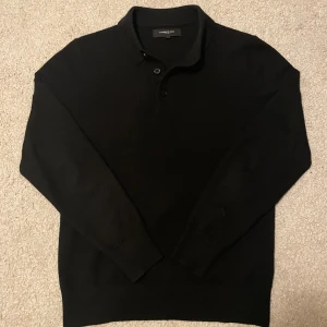 Stickad pikétröja från Lawrence Grey - Säljer en svart stickad pikétröja från Lawrence Grey. Tröjan har klassisk krage och knäppning med tre knappar framtill. Långärmad modell med ribbade muddar vid ärmslut och nederkant. Perfekt för en stilren och enkel look. Också väldigt mjuk & skön.