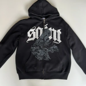 Svart hoodie från multiply apparel - Svart hoodie med dragkedja och stor huva från multiply apparel. Tröjan är i ny skick och har använts få gånger. Hoodien är storlek xs men är översize och är mer som storlek s/m i passformen. Hoodien är också heavyweight och perfekt för alla årstider. För mer info och bilder av plagget så är det bara att fråga.
