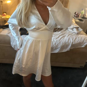 Vit satin klänning - Säljer En oanvänd vit satin klänning med prislappen kvar!  Klänningen är slutsåld och går inte att få tag på