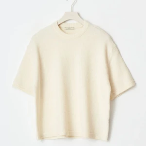 Vit stickad kortärmad tröja från Gina  - ALDRIG ANDVÄND!!!Säljer en stilren vit stickad tröja från Gina tricot med korta ärmar och rund hals. Perfekt för lager-på-lager eller sommarens svalare dagar. Enkel och tidlös design som passar till mycket.