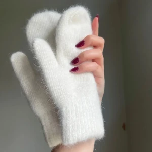 Vita stickade tumvantar - Mysiga vita tumvantar i stickat material med mjuk och fluffig känsla. Perfekta för kalla dagar och håller händerna varma. Klassisk modell med ribbad mudd vid handleden. Jättefina, aldrig använda 
