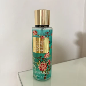 Victoria's Secret Bare Vanilla Splash parfymmist - Fräsch parfymmist från Victoria's Secret i en turkos plastflaska med guldigt lock och blommigt mönster. Doften är söt och blommig, perfekt för dig som gillar lätta och fräscha parfymer. Flaskan rymmer 250 ml.