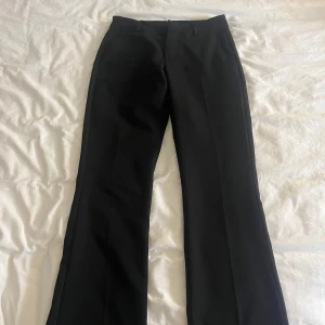Svarta kostymbyxor från BikBok - Säljer ett par klassiska svarta kostymbyxor från BikBok i storlek 34. Byxorna har raka ben och hällor för bälte. Perfekta för en stilren look och passar till många olika outfits. Säljer pga för stor storlek❣️ aldrig använda❣️