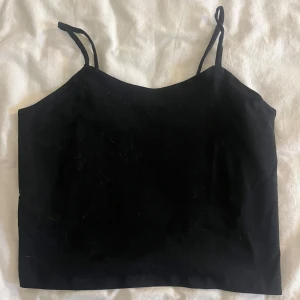 Svart linnetopp från XOXO Friends - Säljer en enkel och stilren svart linnetopp från XOXO Friends. Toppen har tunna axelband och rak passform, perfekt att matcha med vad som helst. Perfekt nu till sommar❣️Aldrig använt och lappen är kvar!!