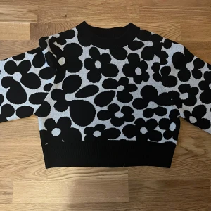 Svartvit blommig stickad tröja från H&M Divided - Säljer en stickad svartvit tröja från H&M Divided. Priset går att diskutera. Säljer pga att den är för liten.