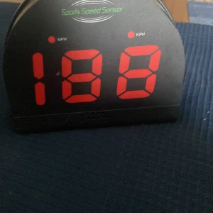 Digital sporthastighetsmätare Revolution - Säljer en digital sporthastighetsmätare med stor röd LED-display som visar hastighet i MPH eller KPH. Svart plastkonstruktion med knappar för olika funktioner på baksidan. Perfekt för att mäta hastighet vid sportaktiviteter. Används aldrig