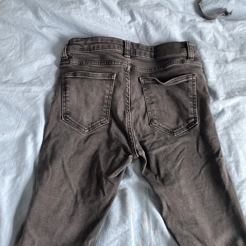 Säljer ett par gråa lager 157 jeans med bootcut passform. Jeansen har klassiska fem fickor, dragkedja och knapp framtill samt utsvängda ben. Perfekta för dig som gillar en retro vibe och vill ha något som sticker ut lite.. Farkut & Housut.