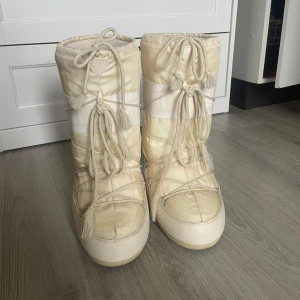 Moon boots  - Säljer mina Moon boots i färgen cream och storlek 38. Använda enstaka gånger under en vinter, så i väldigt gott skick. Säljer för 800kr men kan gå ner i pris vid snabb affär. Nypris 2 290kr.