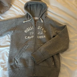 Grå huvtröja från Hollister - Grå tröja från Hollister i storlek L men är liten i storleken så passar även  S-M. 