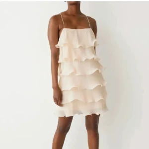 Volangklänning - Supersöt kortklänning i champagnefärg med flera lager volanger och tunna axelband. Ifrån &other stories som är superpopulär! Justerbara band 🎀 