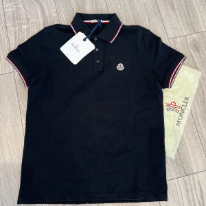 Moncler Piké  - Klassisk svart pikétröja från Moncler i nytt skick. Köpt på plick så kan ej garantera äkthet.Priset är inte hugget i sten, bara att skriva vid frågor. 