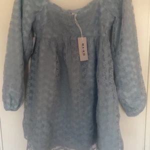 Ljusblå spetsklänning från NA-KD - Supersöt ljusblå klänning från NA-KD med långärmade puffärmar och v-ringad hals. Klänningen är täckt av spets och har en romantisk känsla. Perfekt för vår och sommar! 💙