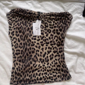 Leopardmönstrad offshoulder topp - Säljer en snygg offshoulder topp från Gina tricot med leopardmönster. Toppen har en tight passform och är tillverkad i ett mjukt, stretchigt material. Perfekt för dig som vill sticka ut med ett djuriskt mönster.