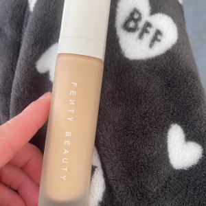 Fenty Beauty foundation - Flytande foundation från Fenty Beauty i en frostad glasflaska med vit kork. Ger en jämn och naturlig finish, perfekt för att skapa en flawless bas. Passar dig som vill ha ett snyggt och hållbart resultat.
