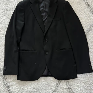 Svart Kostym från Riley - Fin svart kostym (kavaj+byxa) från Riley.  Kavaj storlek: 48 Byxa storlek: 50 Bra skick! Inga skador. Använd fåtal gånger. 
