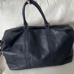 Weekend bag Mulberry - Säljer en stilren svart läderväska från Mulberry. Väskan har ett rymligt inre med ett mönstrat foder. Perfekt för att bära med sig allt man behöver över en weekend. Äkta. Saknar kvitto. Den man håller i på dragkedjan är sönder men funkar utan problem- därav billiga priset. 