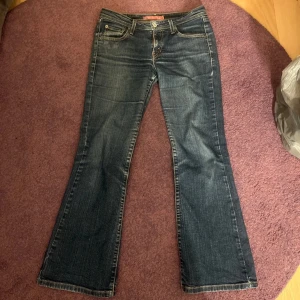 Levis 527 bootcut jeans - Mörkblå Levis 527 jeans med bootcut passform och klassiska fem fickor. Byxorna har låg midja och är tillverkade i mörk blå denim. Köptes i italien men tyvärr är dom för korta på mig