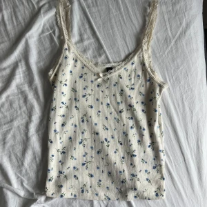 Blommig topp - Blommigt linne med fina detaljer. Benvit/cremevit. Kolla gärna in mina andra annonser och få rabatt vid köp av flera varor. Det finns just nu möjlighet till fri frakt!!