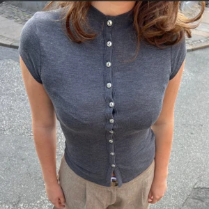 Grå t-shirt med knappar - Grå tröja med knappar från design by si, storlek m/l,  använd 1 gång 🥰