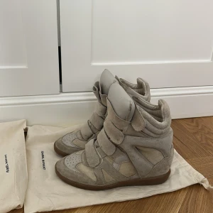 Beige sneakers med kilklack från Isabel Marant - Säljer ett par beige sneakers med kilklack från Isabel Marant. Får även med två dustbags vid köp! 🥰